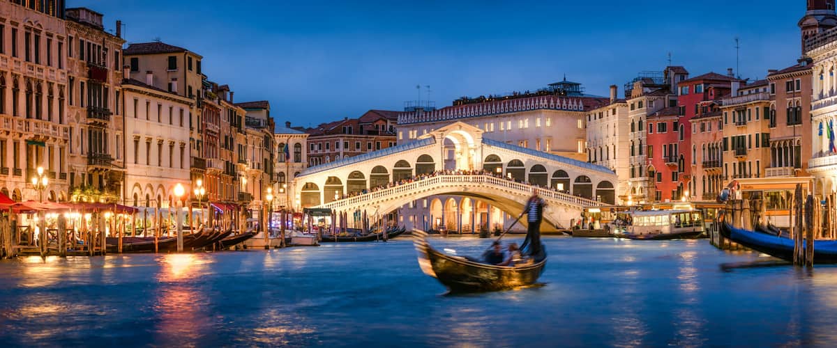 A canal with gondolas, a bridge, and historic buildings in Venice.