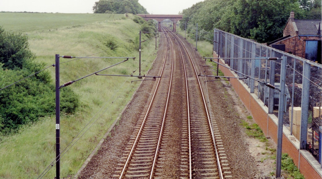 Southward up the ECML at site of Tuxford North station, 1992. View up the ex-GNR Doncaster - London section of the East Coast Main Line, electrified 1989. Nothing is left of the station, which closed 4/7/55 to passengers, 15/6/64 to goods. Just beyond the bridge ahead there had been a loop to the west connecting with the ex-GCR (Lancashire, Derbyshire & East Coast) line, which crosses the ECML shortly beyond at the former Dukeries Junction station