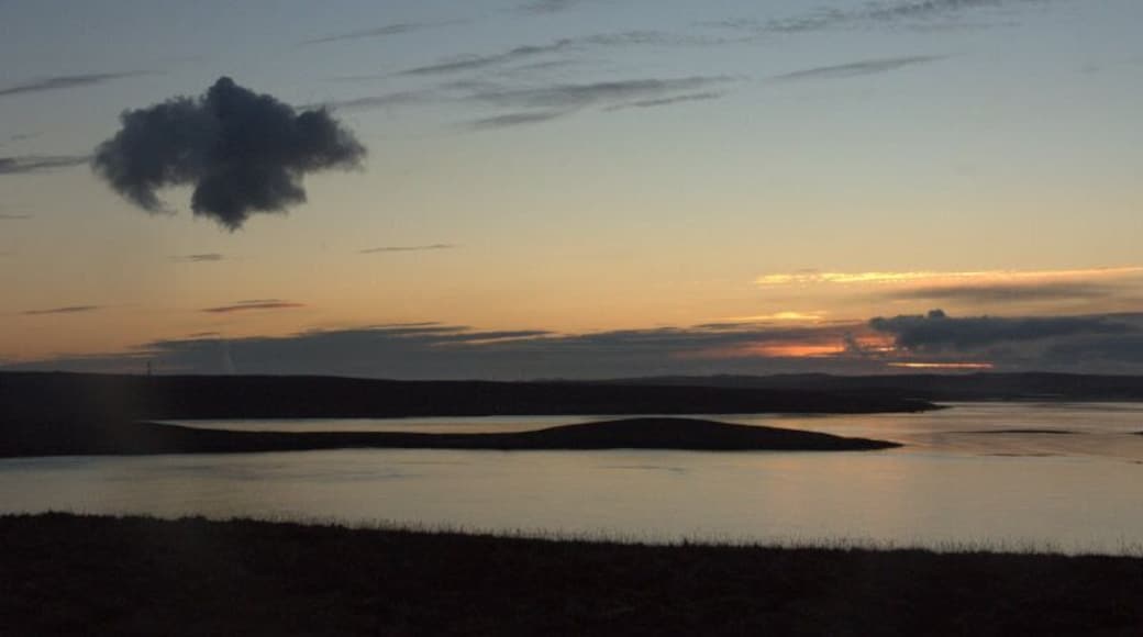 View over Yell Sound at dusk Looking across the island of Bigga towards Mainland. The strange cloud is actually something to do with Sullom Voe - a thin plume of white smoke coming from the flare stack becomes invisible for a while before condensing as a dark cloud higher up.
