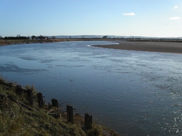 Longney Crib on the river Severn. Longney Crib is a narrow section of the river Severn. The tidal bore after its journey around the magnificent horseshoe bend at Newnham now starts to get squeezed. The photo is looking south towards the crib. The tide is receding leaving large areas of sand and mud.
