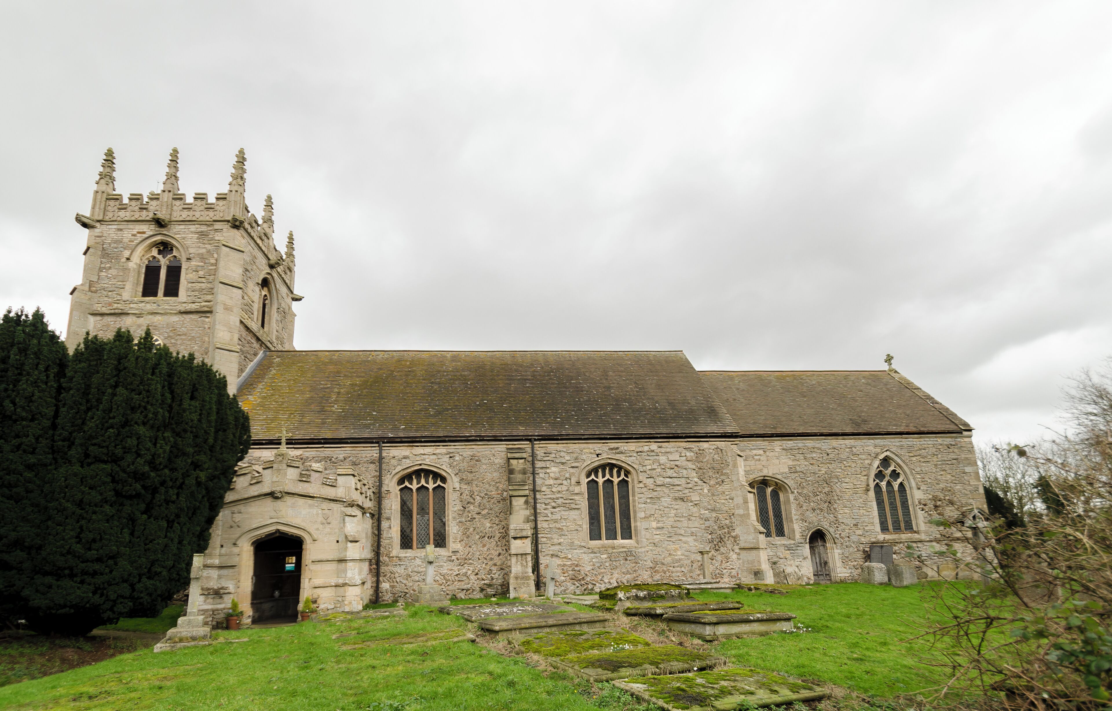 A stone church with a tall tower and arched windows.