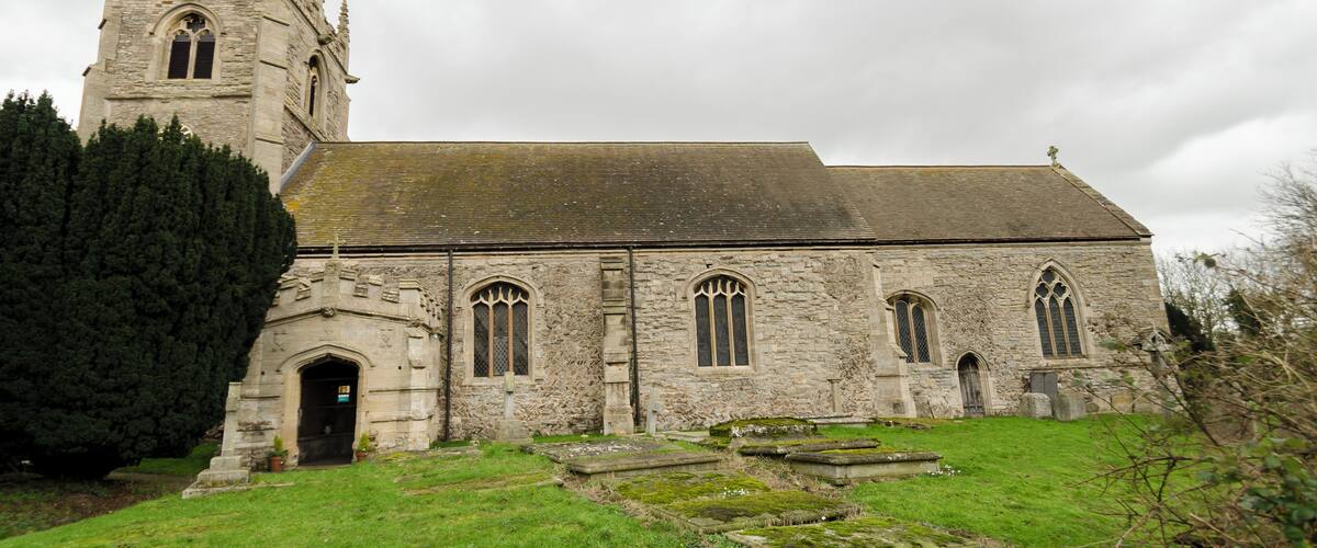 A stone church with a tall tower and arched windows.
