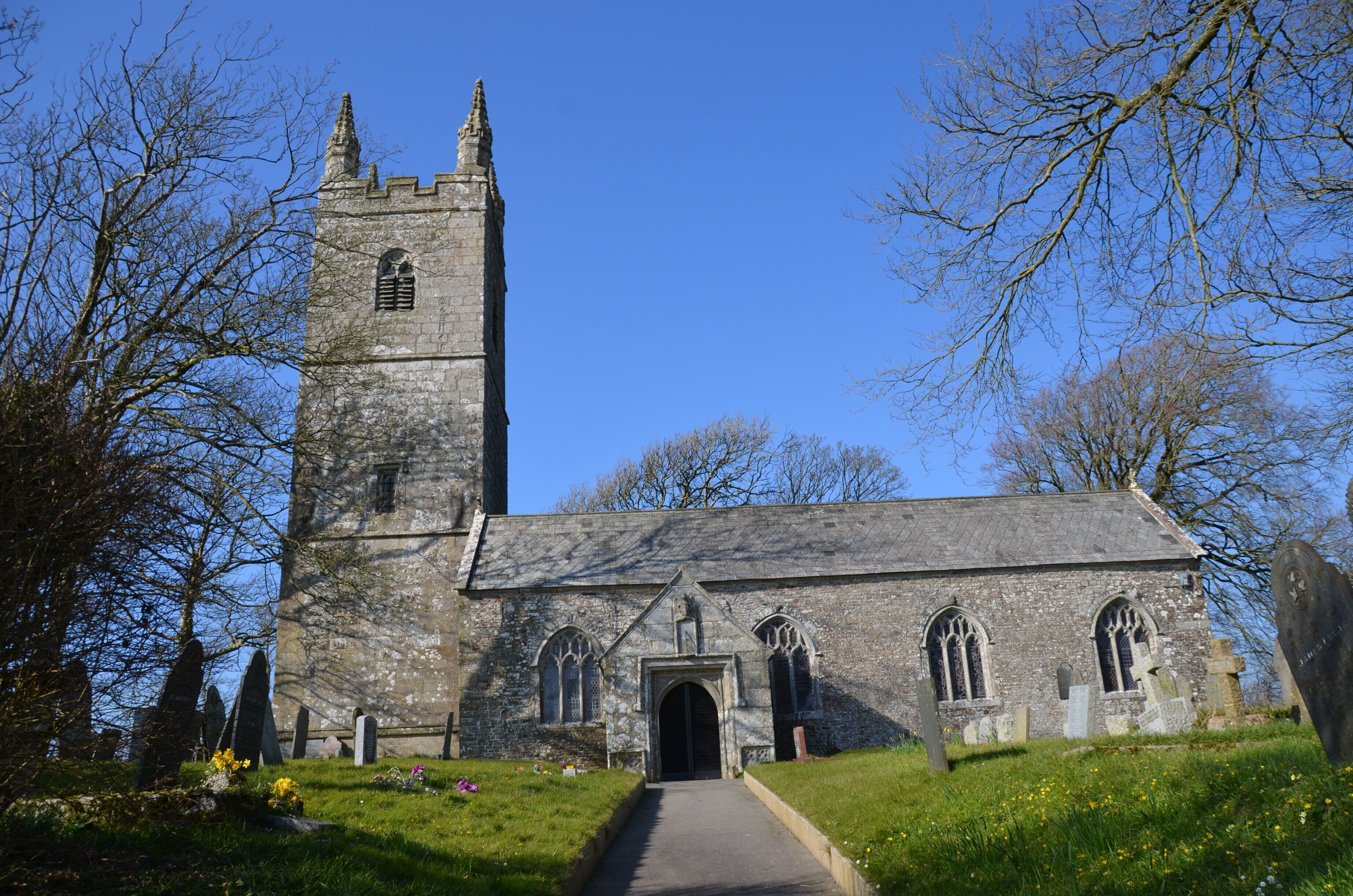 A stone church with a tall tower and arched windows.
