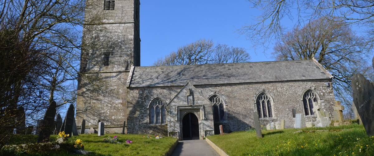 A stone church with a tall tower and arched windows.