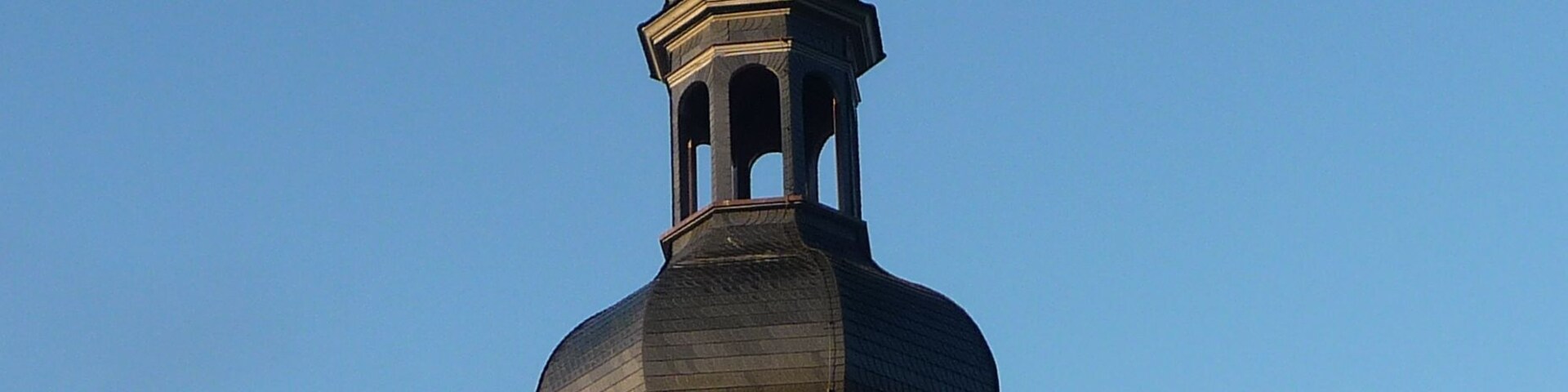 A church with a prominent dome and a weather vane on top.