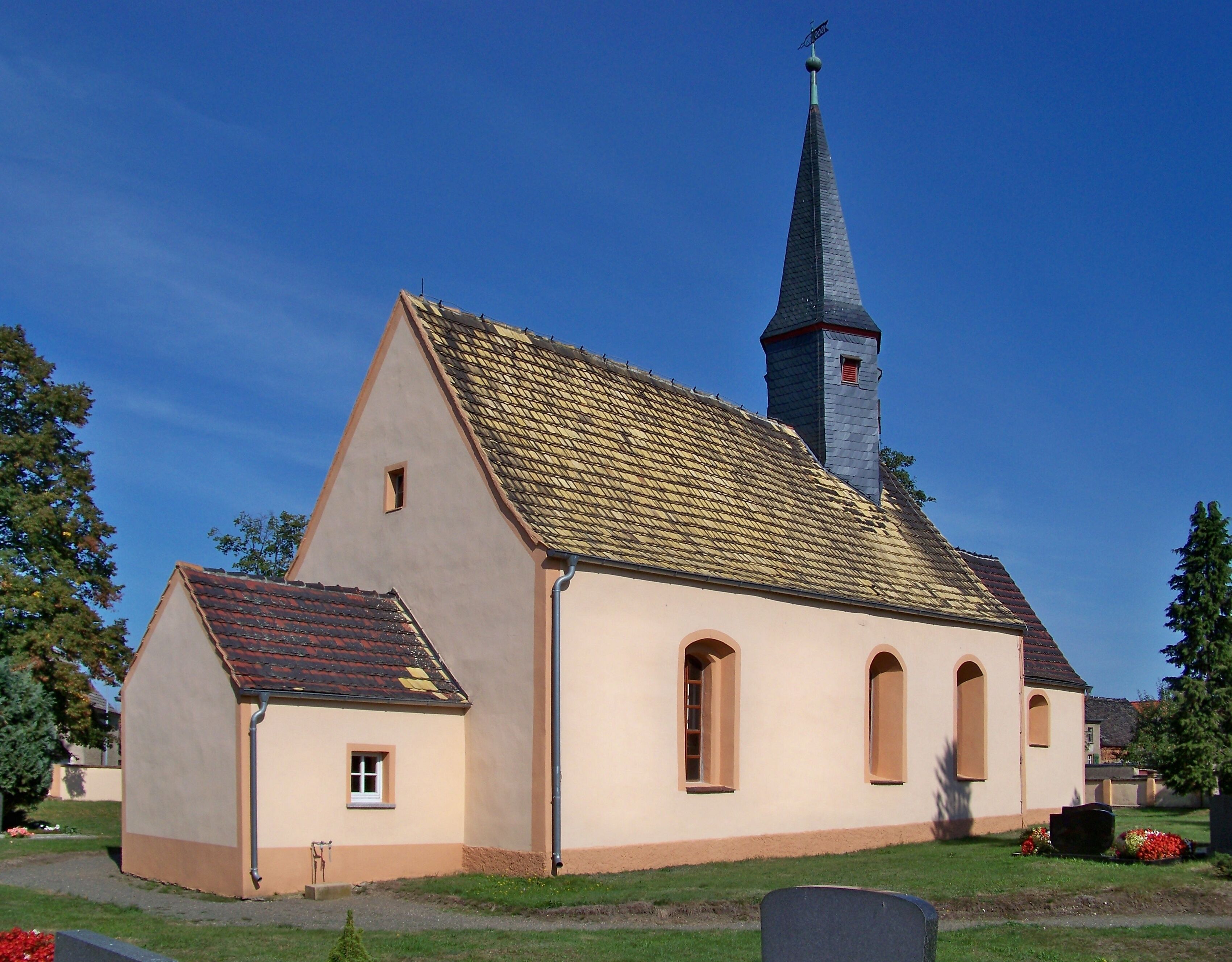 A church with a tall steeple and a tiled roof.