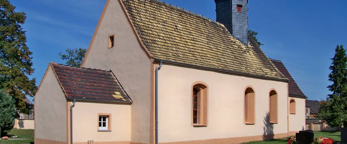 A church with a tall steeple and a tiled roof.