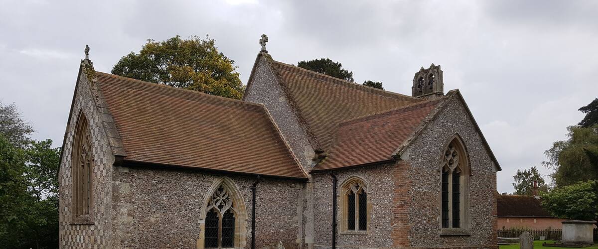 A historic stone church with a tiled roof and arched windows.
