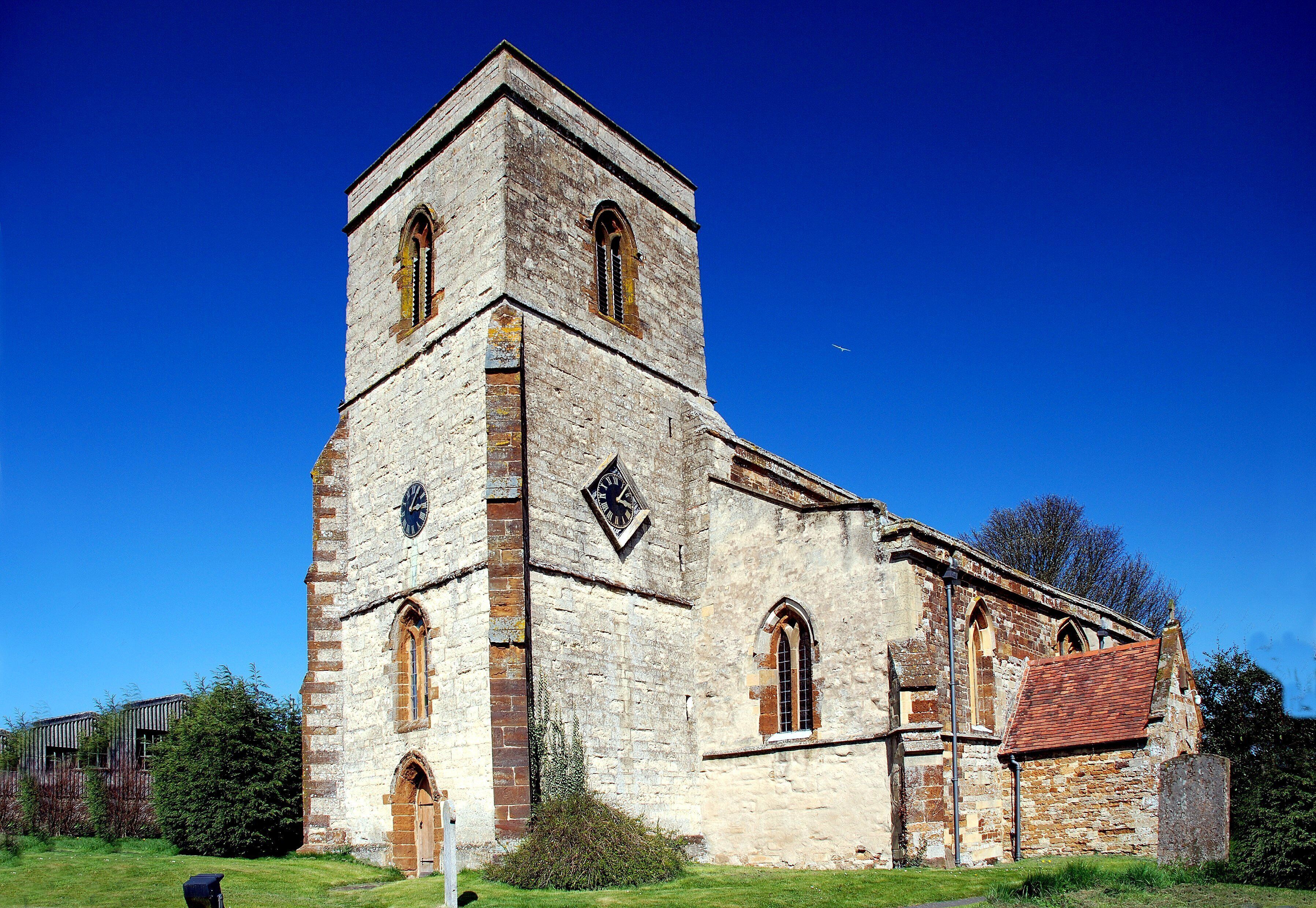 An old stone church with a bell tower and arched windows.