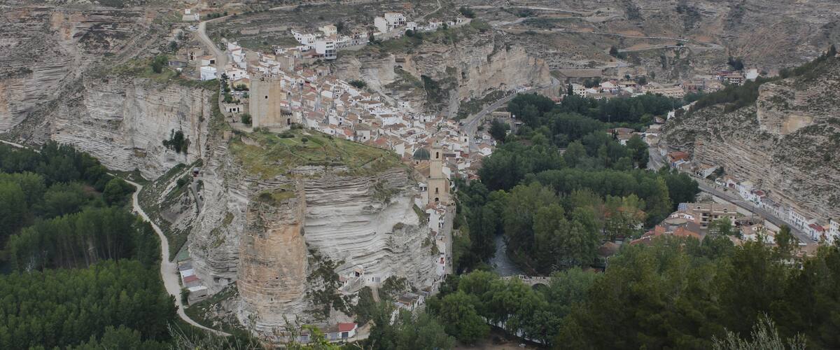 A town nestled in a valley with terraced houses and a prominent church.