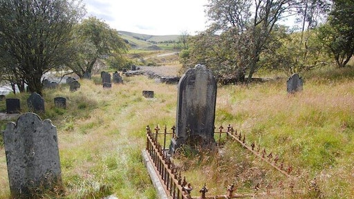 Churchyard and Demolished Church, Dylife Beyond the central headstone the base of Dylife's former church, now demolished, can be seen.
