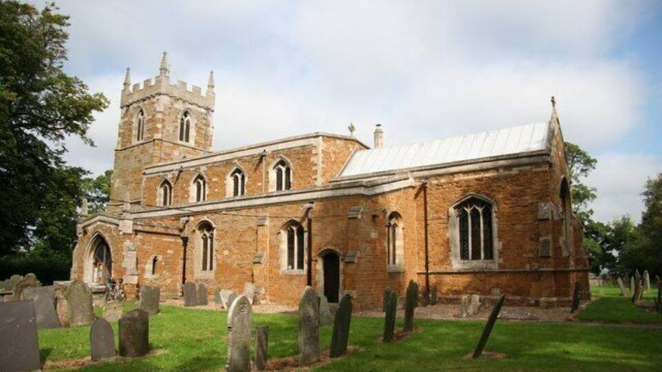 A historic church with a tower and a graveyard.