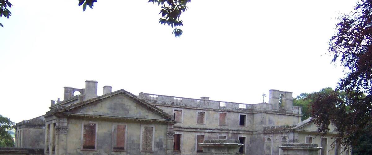 An old, large stone building with multiple windows and a central entrance.