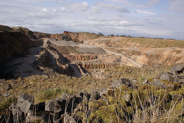 A barren landscape with a dirt road and rocky terrain.