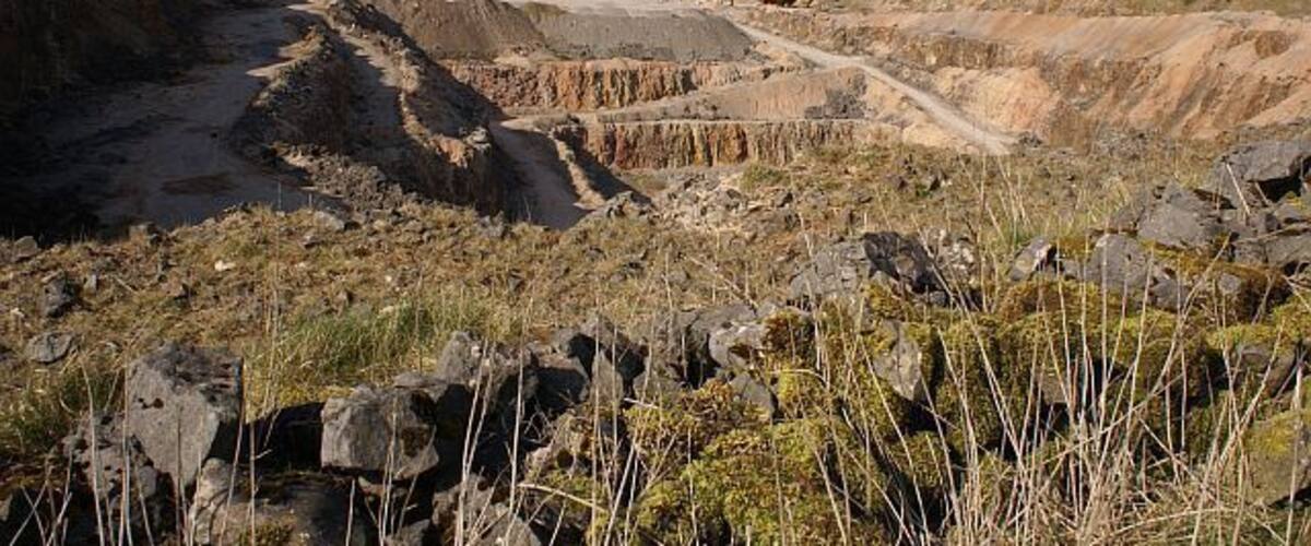 A barren landscape with a dirt road and rocky terrain.