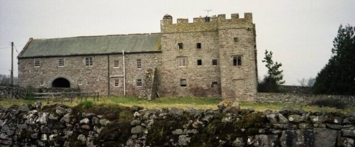 A stone castle with a tower and a large arched entrance.