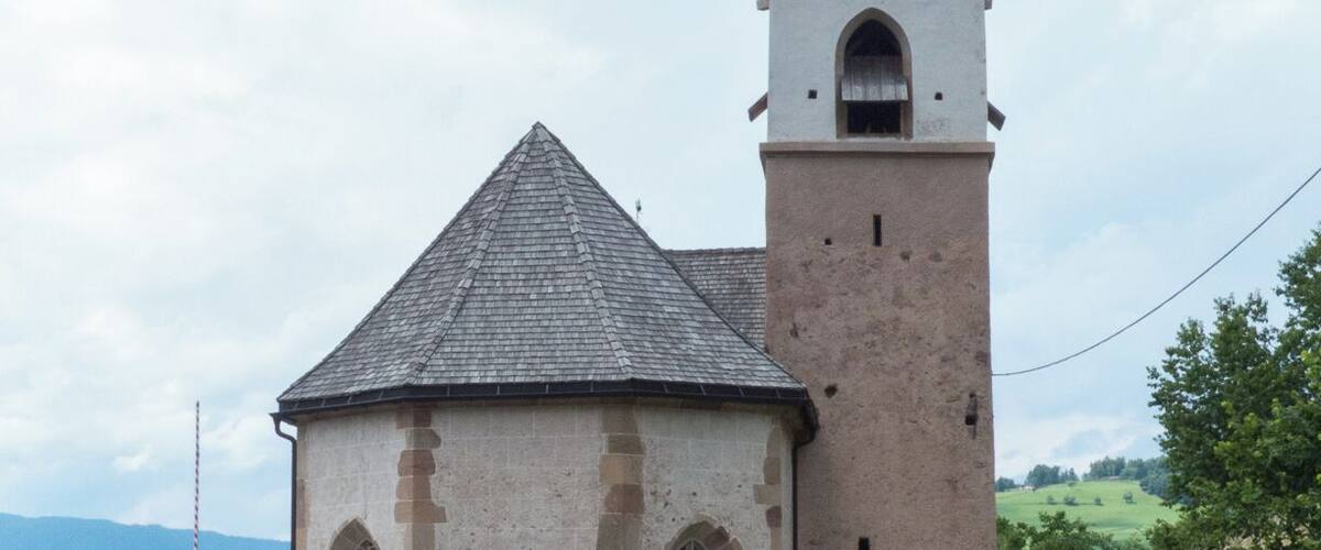 A church with a bell tower and a smaller adjacent building.