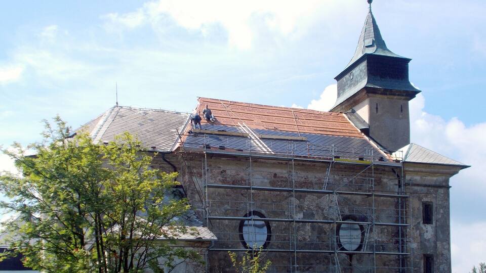 A historic building with a clock tower and scaffolding.