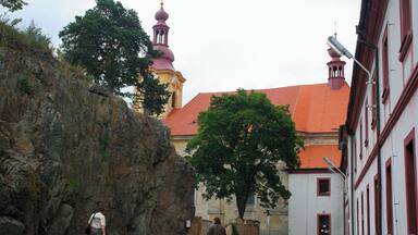 Monastery with the Church of Our Lady of Sorrows...
Cz.
Klåƥter servitƯ s kostelem Panny Marie Sedmibolestné
Laza transformed its headquarters Manetin a number of monumental sculptures in pearl Baroque and in the same style and pleasing face RabĆĄtejna. On the south side of the castle area he was also in the years 1766 - 1767 probably by the architect Anselmo Lurago built the church of Our Lady of Sorrows . The new church became after the monastery of the Servites in the year 1767 the parish and the original parish church of St. Matthew, which stood between today's churches and castles, the year 1787 was demolished.
Meaning RabĆĄtejna declining gradually. The distance from the center of the manor and cramped residential area hampered the development of industrial and other buildings. The population is fed unprofitable agriculture and handicrafts, among which excel particularly weaving. The year 1836 , there were 20 states. In addition to the typical crafts There were also two workshops on painting playing cards. The last noble owner of until the year 1945 was Theresa Seilern-Aspang, born LaĆŸanskĂĄ.