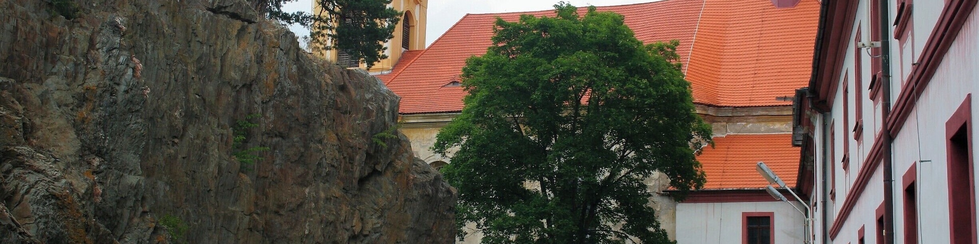 Monastery with the Church of Our Lady of Sorrows...
Cz.
Klášter servitů s kostelem Panny Marie Sedmibolestné
Laza transformed its headquarters Manetin a number of monumental sculptures in pearl Baroque and in the same style and pleasing face Rabštejna. On the south side of the castle area he was also in the years 1766 - 1767 probably by the architect Anselmo Lurago built the church of Our Lady of Sorrows . The new church became after the monastery of the Servites in the year 1767 the parish and the original parish church of St. Matthew, which stood between today's churches and castles, the year 1787 was demolished.
Meaning Rabštejna declining gradually. The distance from the center of the manor and cramped residential area hampered the development of industrial and other buildings. The population is fed unprofitable agriculture and handicrafts, among which excel particularly weaving. The year 1836 , there were 20 states. In addition to the typical crafts There were also two workshops on painting playing cards. The last noble owner of until the year 1945 was Theresa Seilern-Aspang, born Lažanská.
