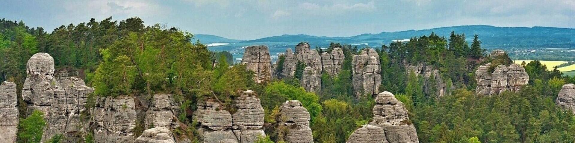 May 2015
Vyhlídka na Kapelu, Hrube rocks, Bohemian Paradise, Czech republic
Bohemian Paradise (=Český Ráj) is a nature reserve protected area established in 1955 and it is located in North Bohemia. It has a varied country side with plenty of first and beech surrounding wonderful sandstone rock formations. The water, wind and frost erosion has left many uniquely shaped rock towers having up to 60 meters of height and these are a popular place for Czech rock climbers for decades.
In the picture is the main part of Hrube rocks in Bohemian Paradise. This panoramic viewpoint is called View of the Orchestra. The Orchestra is the group of the sandstone towers on the left, with one needle standing before them, which is called the Dirigent. On the right in the background is the Lighthouse area with Lighthouse and Gate rocks.