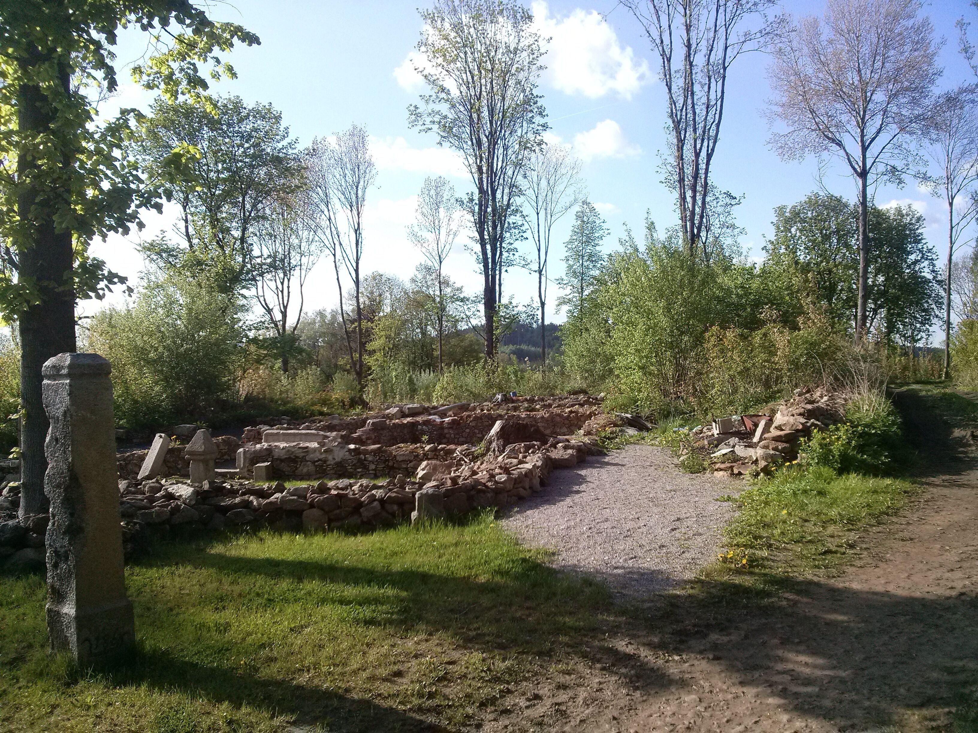 An archaeological site with stone ruins and a gravel path.