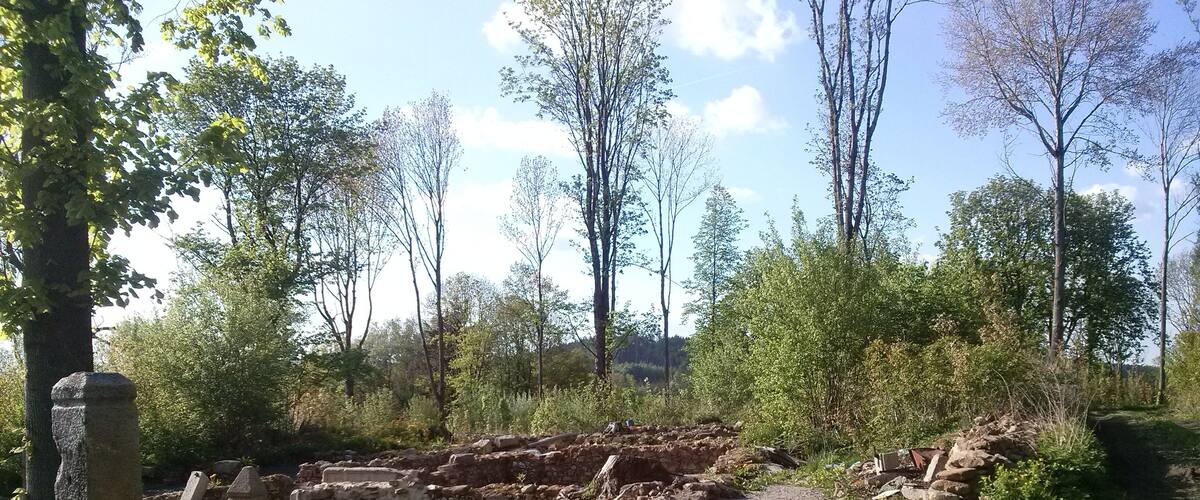 An archaeological site with stone ruins and a gravel path.