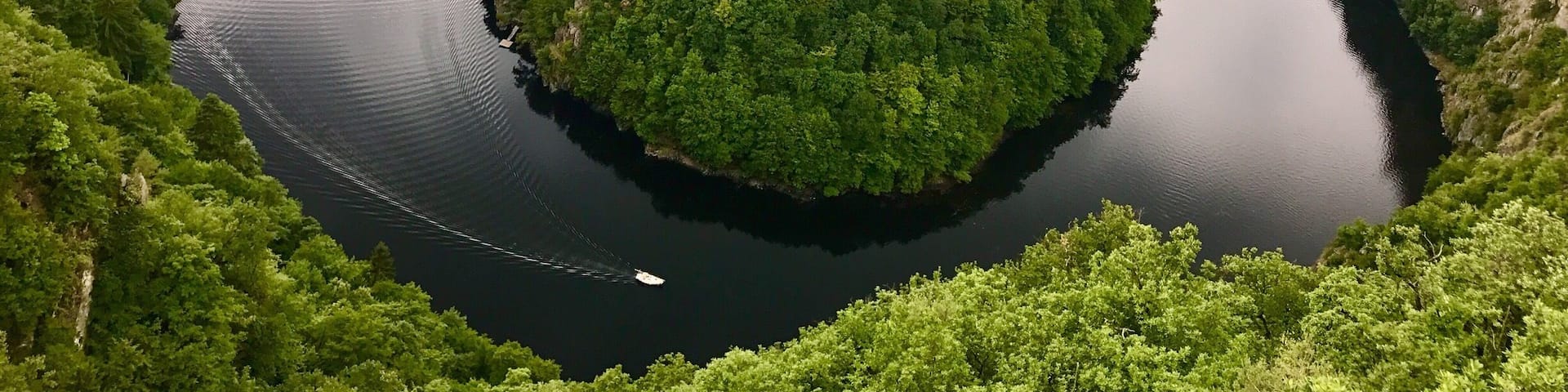 A river winding through a densely forested valley with steep cliffs on either side.
