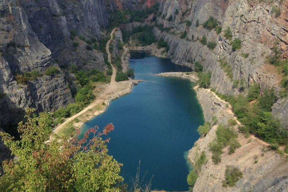 Un lago azul intenso rodeado de riscos escarpados.