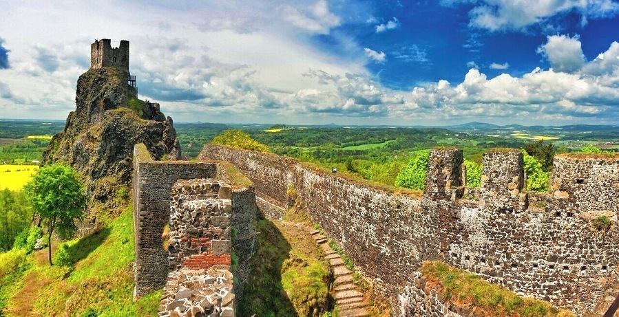 May 2015
Castle Trosky, Český ráj, Czech republic
Trosky is a castle ruin located some 10 km south of Semily, Liberec Region in a natural reservation region called Český ráj (=Bohemian paradise) making a landmark of jt. It is one of the most famous Czech castles and is situated on the summits of two basalt volcanic plugs. On the lower peak (47 m) is the two-storey structure called Baba (Old Woman), and on the higher outcrop (57 m) is the four-sided structure known as Panna (Virgin, in the picture).
It was built in 1380 and was used for a century. It is a ruin since 1648 when it was burned down during the Thirty years war. Since 1928 a propery of the Club of Czech tourists and a popular tourist spot.
