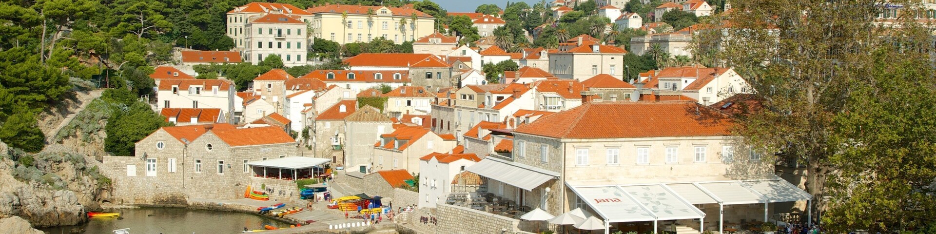 Uma vila costeira com edifícios de pedra, um porto e um muro de pedra.