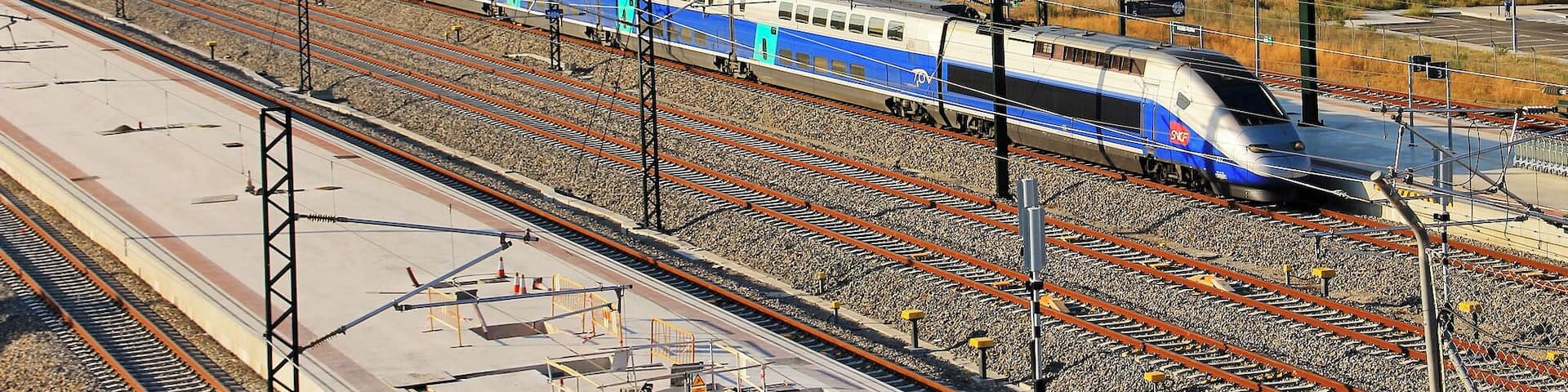 TGV llegando a la estaciĂłn de Figueres - Vilafant. DetrĂĄs, en la colina de la derecha, el Castell de Sant Ferran.