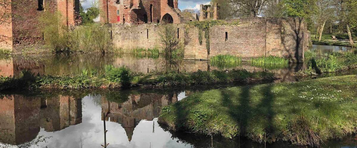 A historic castle with ruins and a moat.