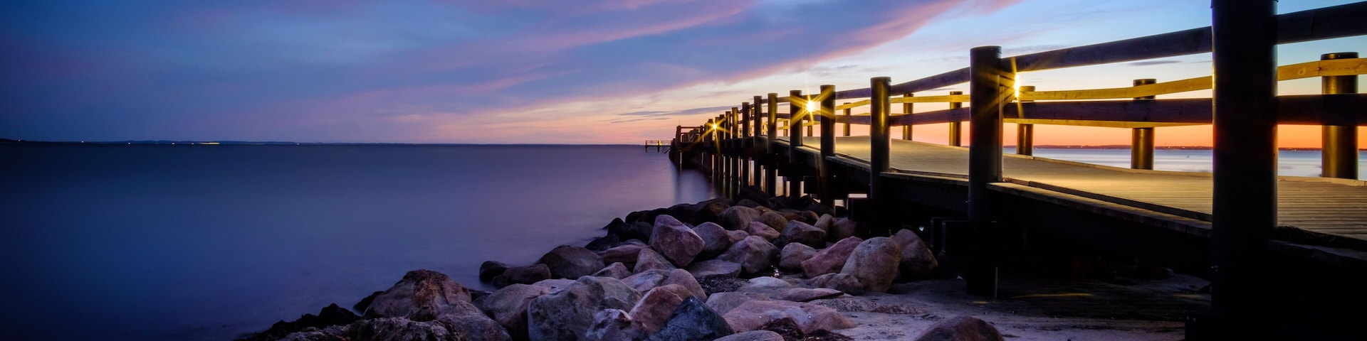 Sunset behind the pier at Rydebäck beach in Sweden