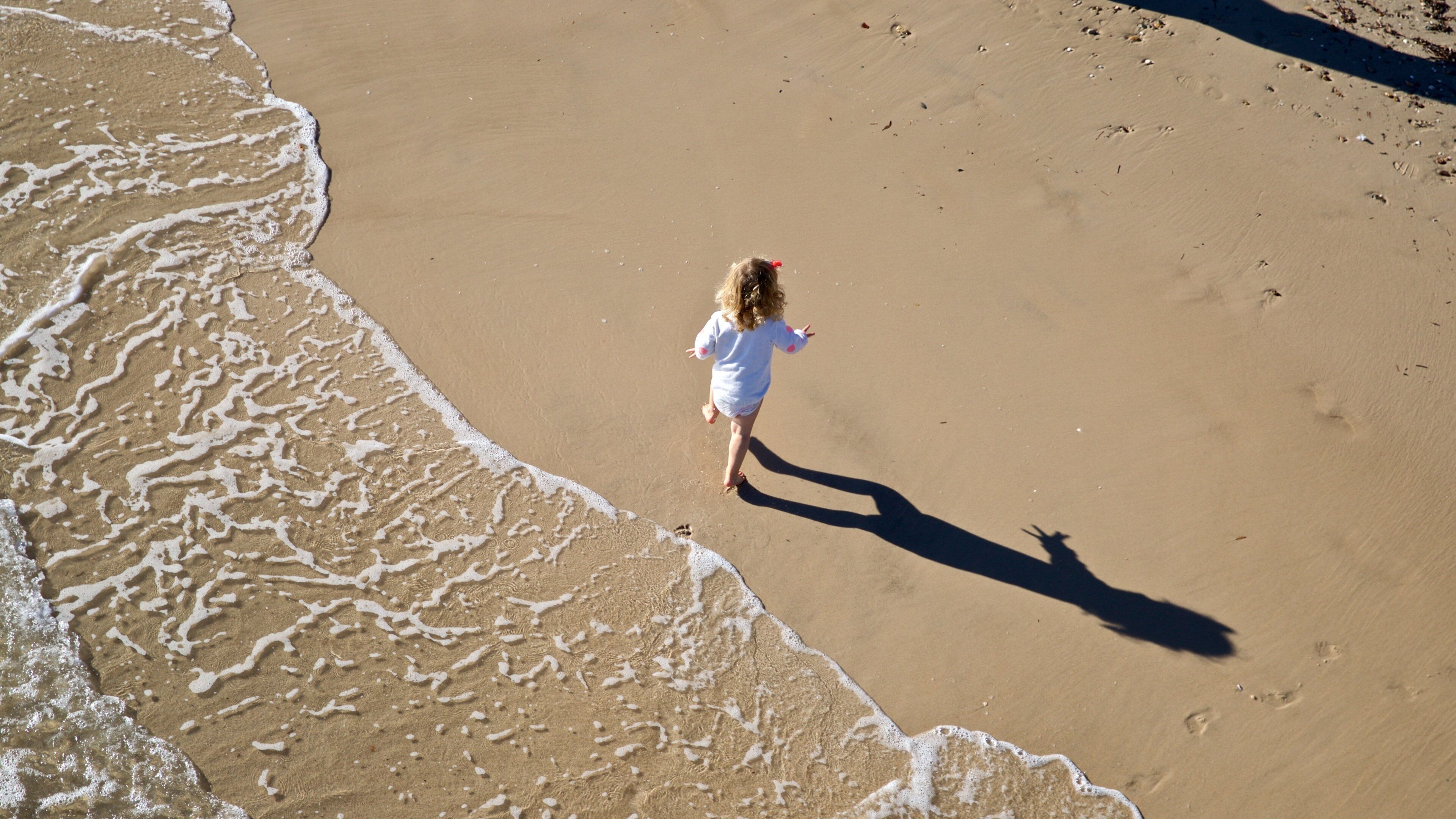 Brighton Beach featuring a sandy beach and general coastal views as well as an individual child