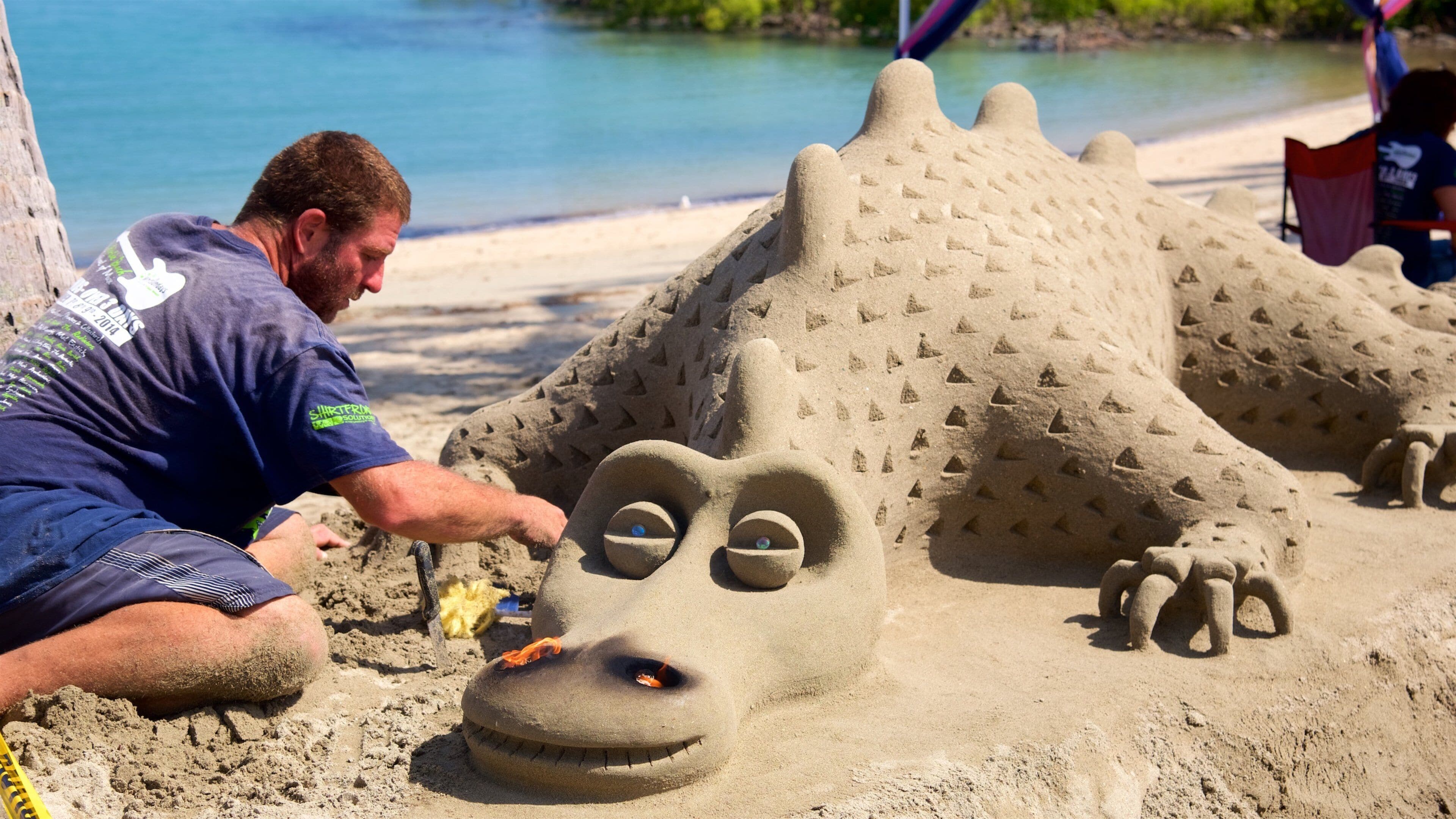 Airlie Beach which includes outdoor art and a sandy beach as well as an individual male