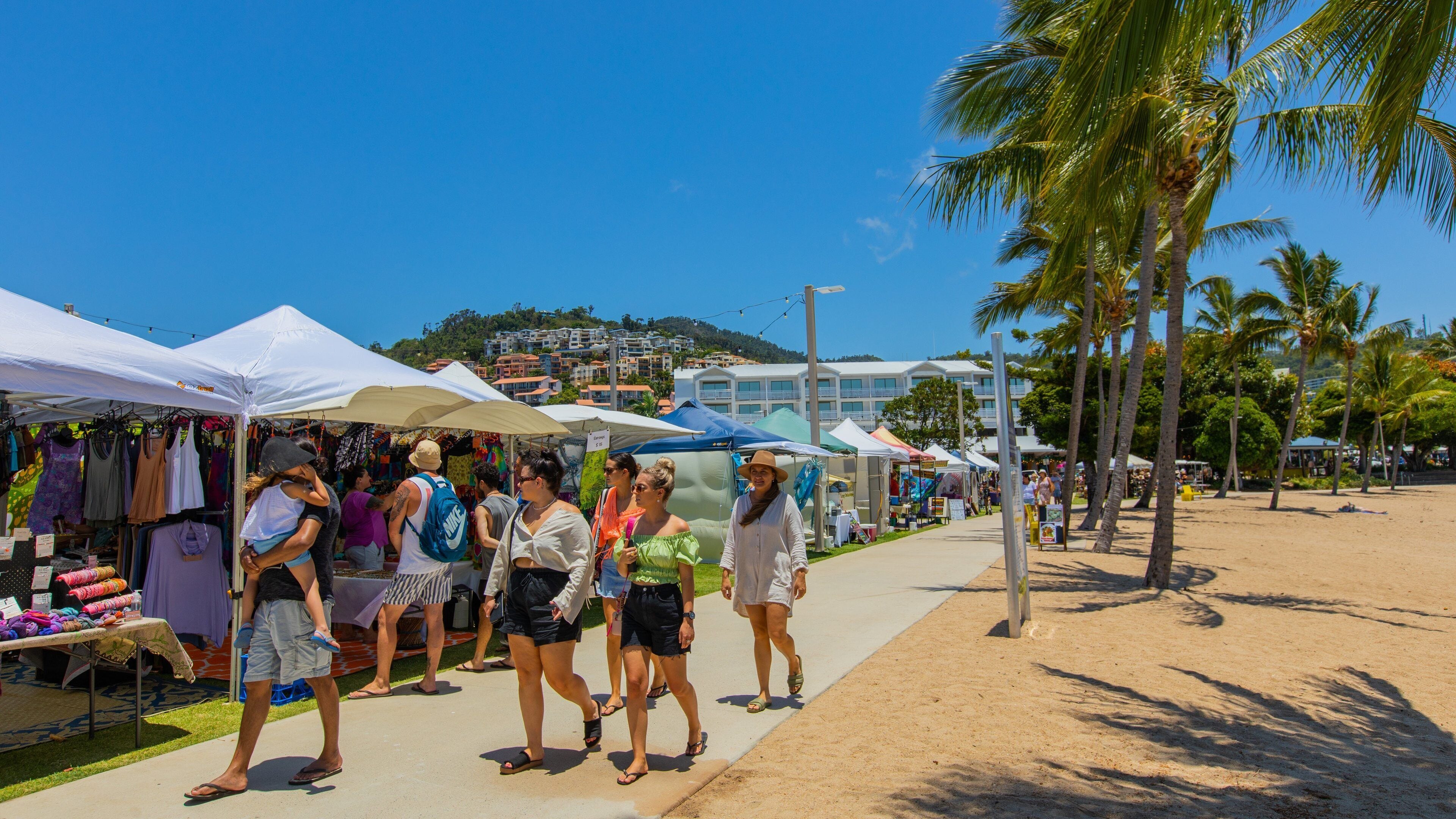 Airlie Beach Market featuring markets and street scenes as well as a small group of people