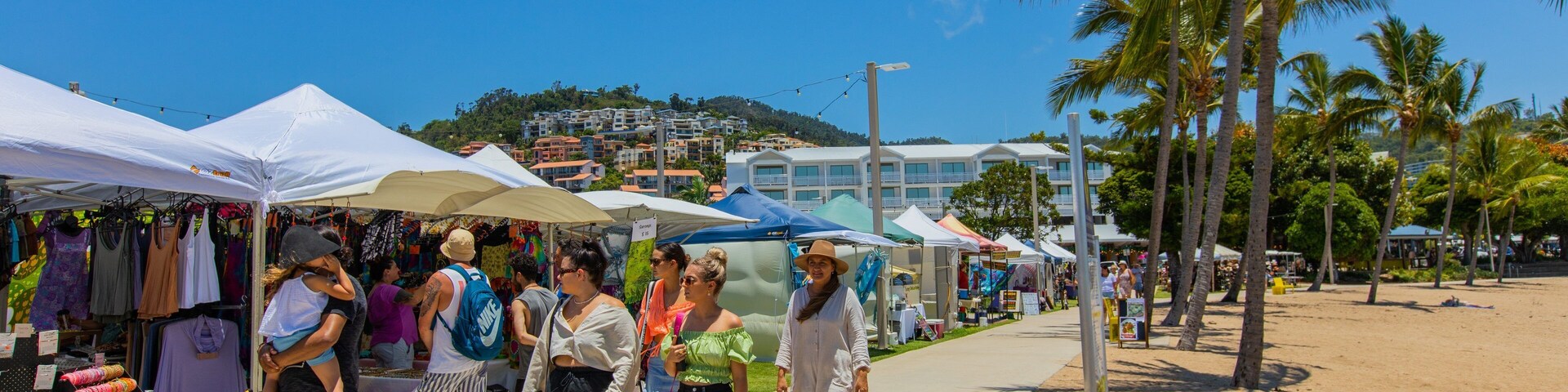 Airlie Beach Market featuring markets and street scenes as well as a small group of people