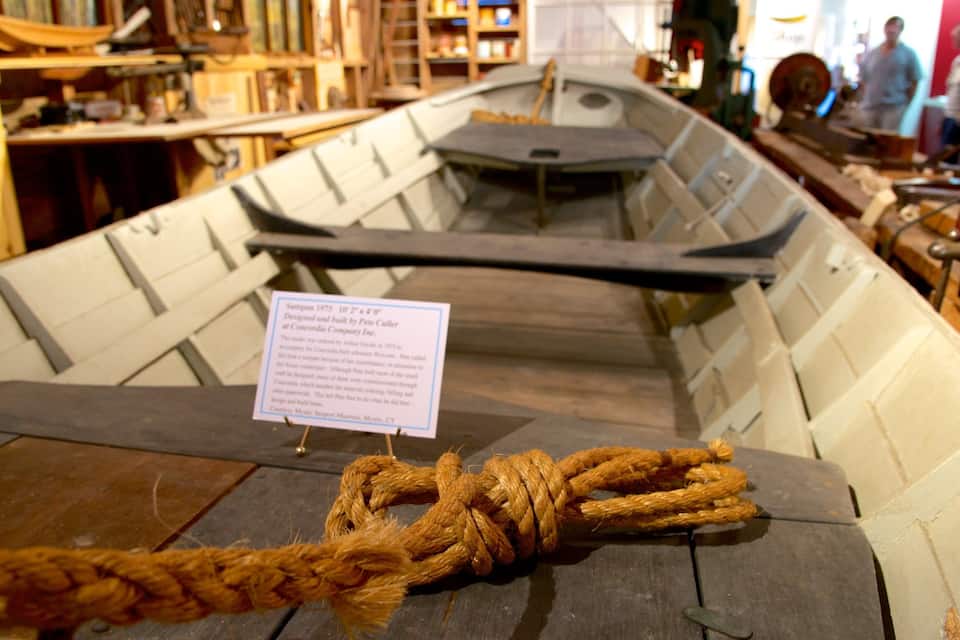 A model boat with a rope tied around it, displayed in a museum setting.