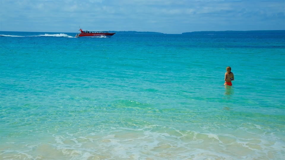 A clear turquoise sea with a boat named 'Explorer' and a person in the water.