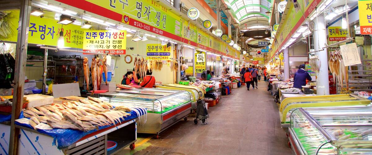 A busy indoor market with various stalls selling seafood and other goods.
