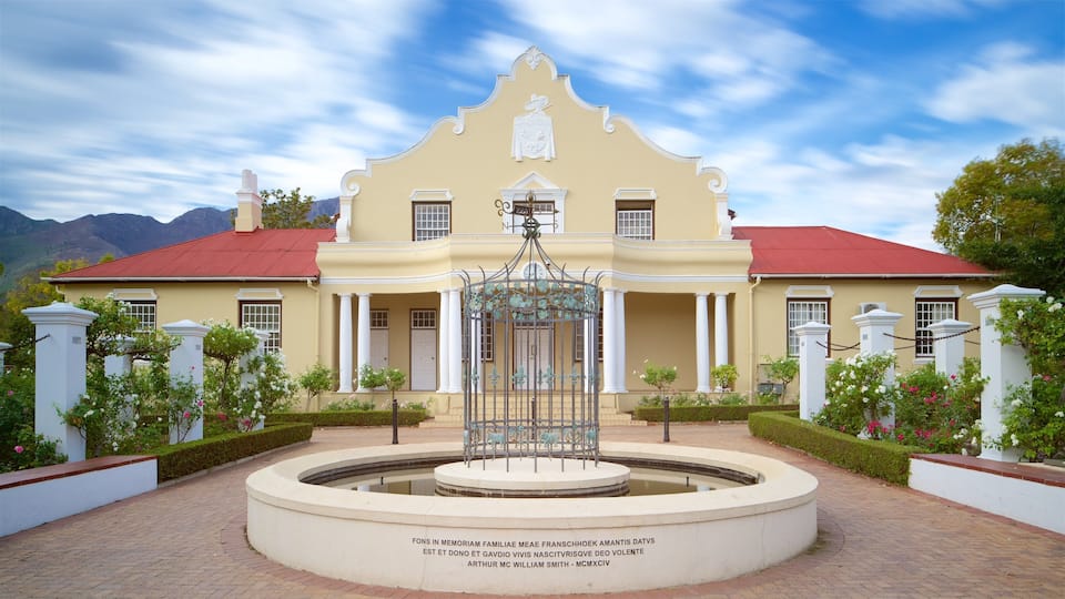 A stately building with a fountain in the center, surrounded by white columns and a red roof.