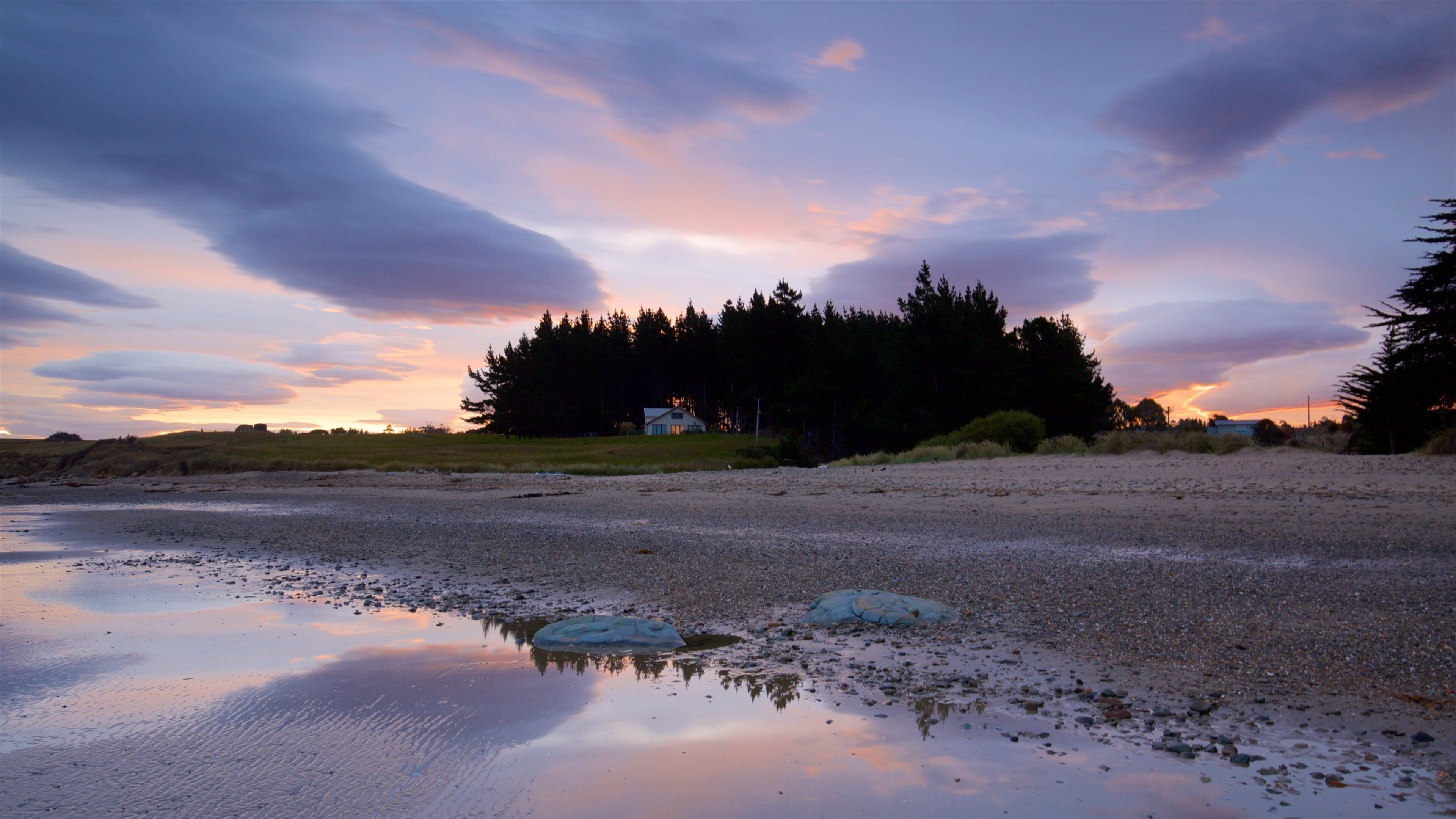 Oamaru featuring a bay or harbor, a sandy beach and a sunset