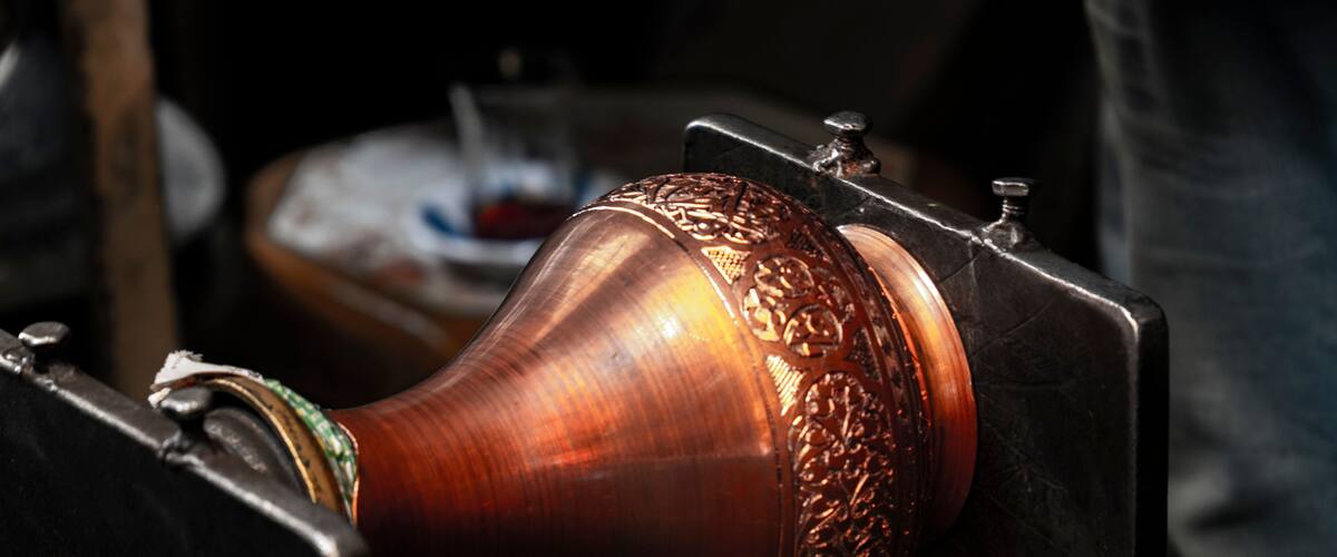 A polished wooden object with intricate carvings, likely a part of a larger piece of furniture or decor.