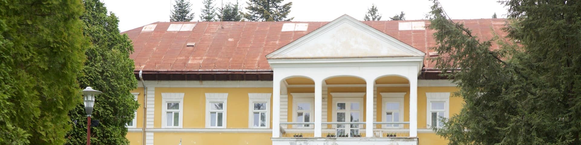 A yellow building with a statue in front.