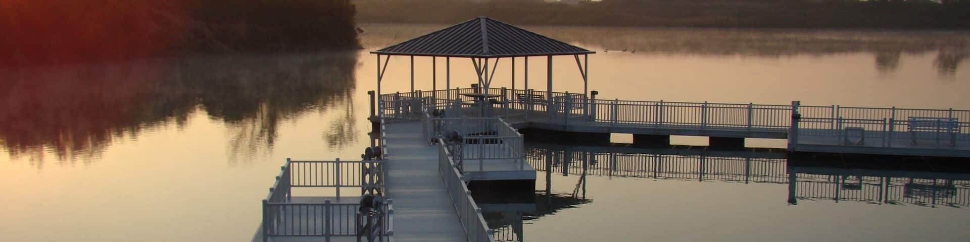Champaign featuring a lake or waterhole and a sunset