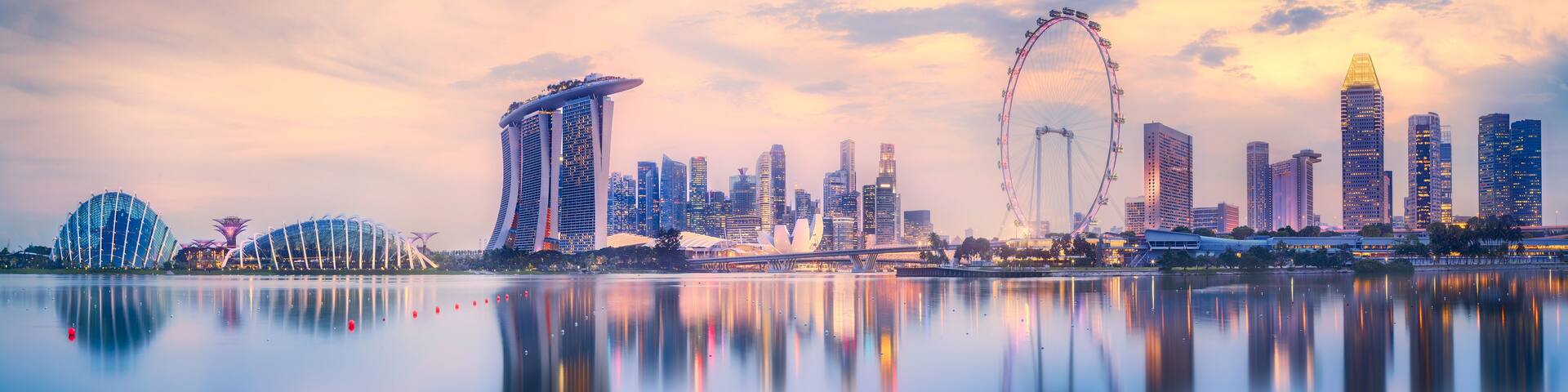 A city skyline with a prominent Ferris wheel and modern architecture.