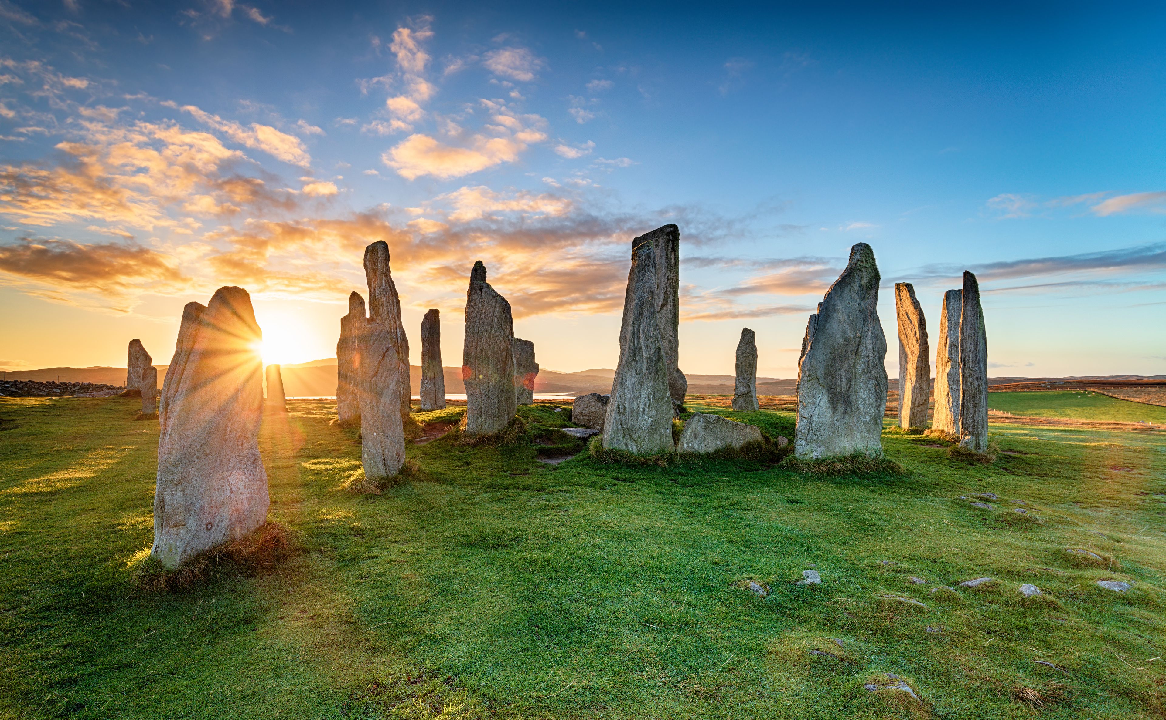 A landscape with standing stones at sunset.
