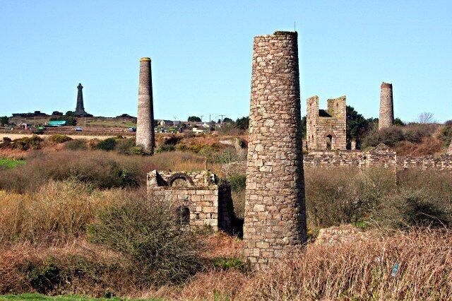 West Basset Stamps This is the remains of the buildings which housed machinery to crush, grade and concentrate the ore to make it ready for sale. On the horizon at the top of Carn Brea Hill is the De Dunstanville Memorial, a memorial to one of the Bassett family. The Bassetts were big landowners hereabouts in the 19th century. Landowners were just about the only people who were guaranteed to get rich from mining as they took a percentage of everything sold without having to invest a penny in any mines on their land.