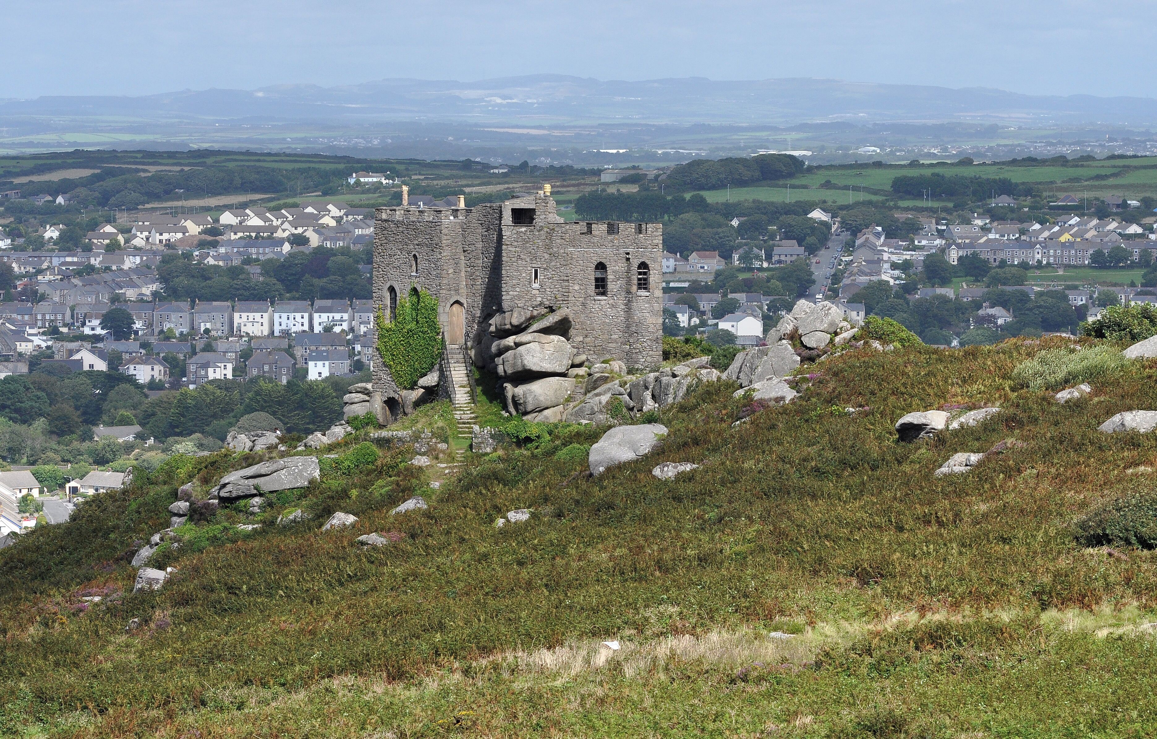 A historic stone castle on a hill overlooking a town.
